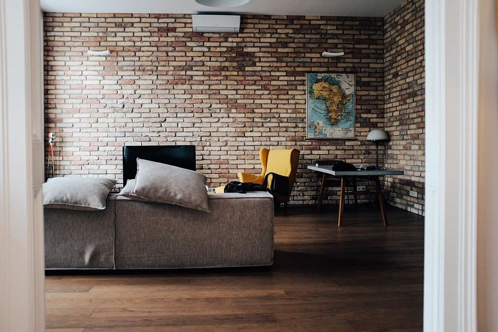 A cosy living room with a TV and a brick wall