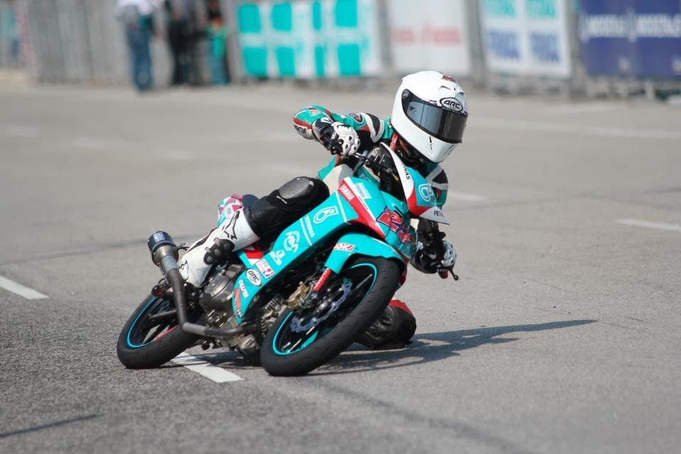 A motorbike racer leaning hard into a corner